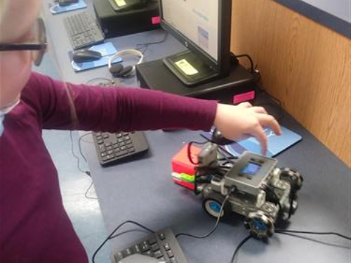 Magothy River studens creates a robot using Vex I.Q. robotics - picure shows student and robot